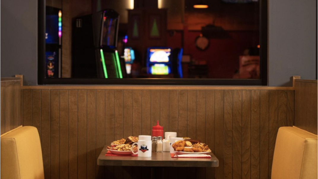 a diner booth with yellow coloured seats and a table with food