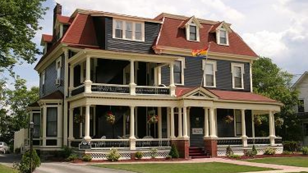 External shot of a three-story victorian-style house.