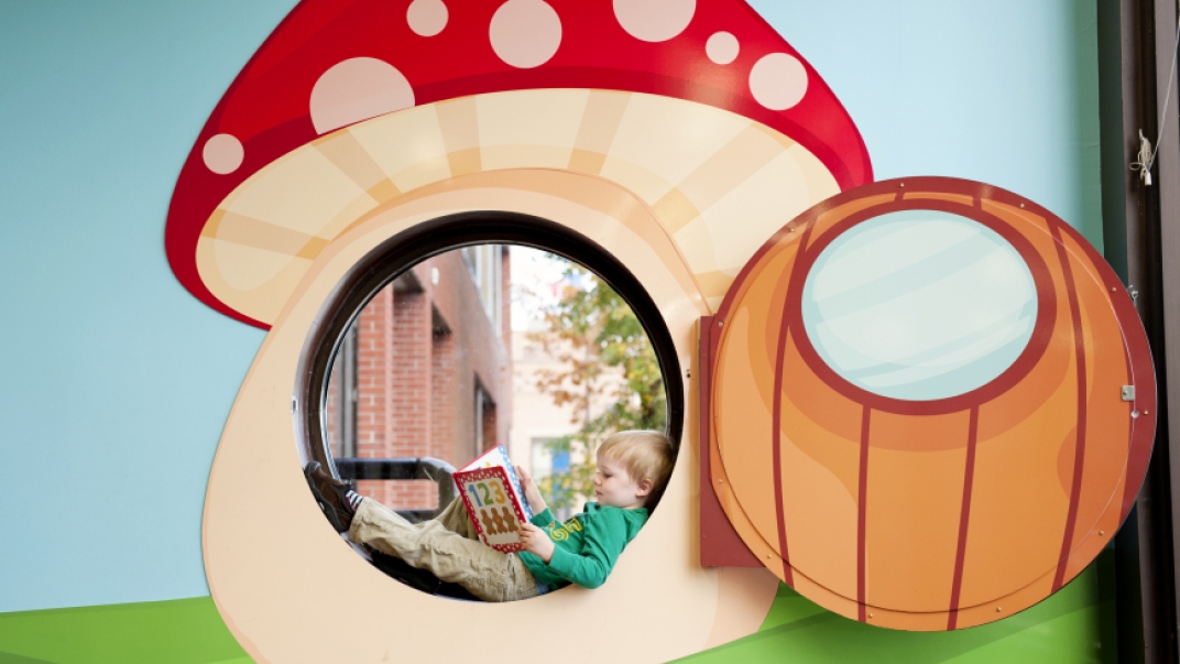 Child reading inside mushroom cutout