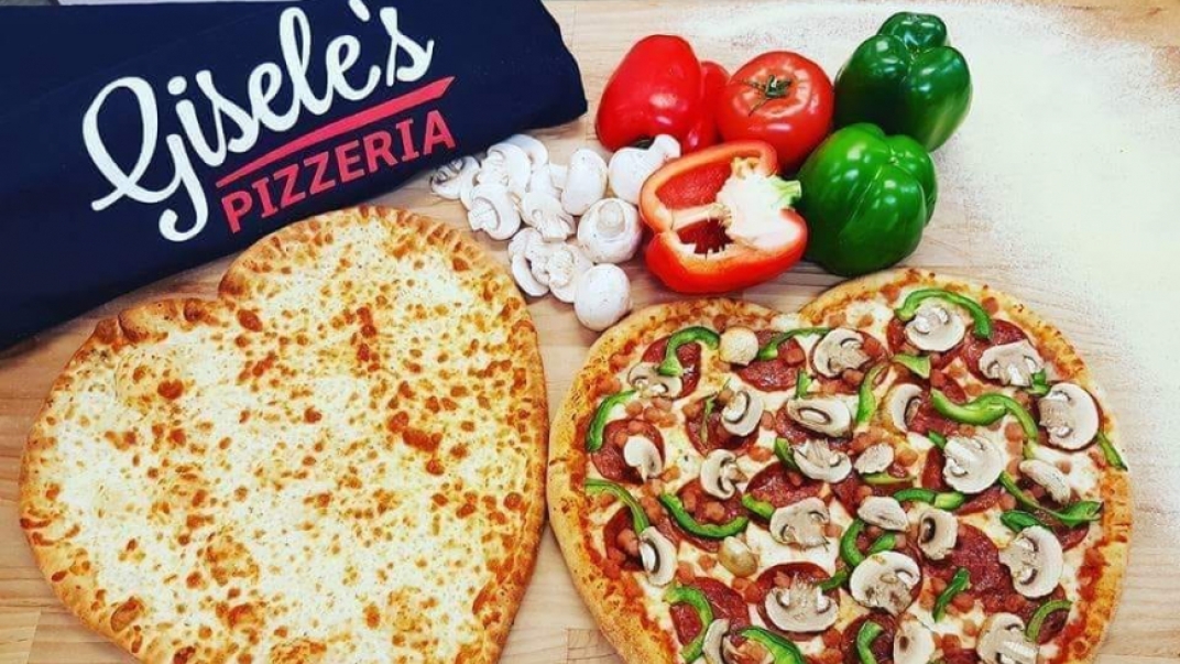 two heart shaped pizzas with a gisele's shirt and some veggies