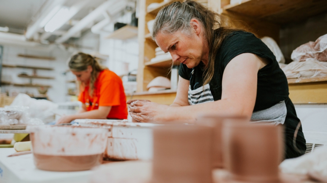 Two women in a workshop working with clay