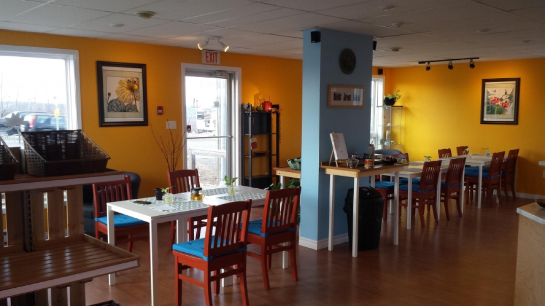 Inside of Lotus restaurant with yellow and blue walls with tables and chairs set up 