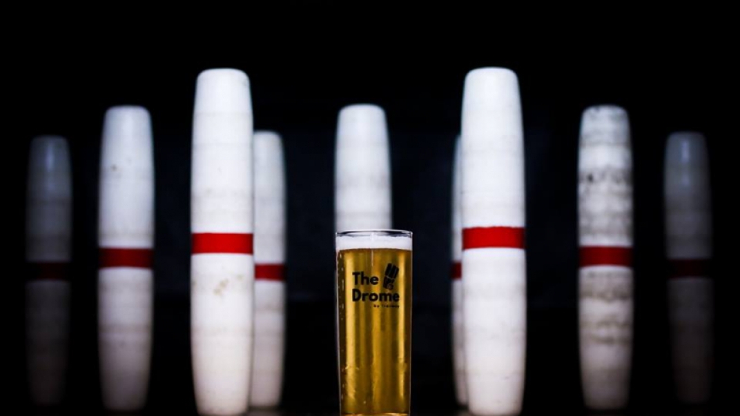 Bowling pins surrounding a pint of beer