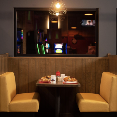 a diner booth with yellow coloured seats and a table with food