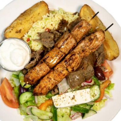 A souvlaki plate with kebabs, a salad, and rice. 