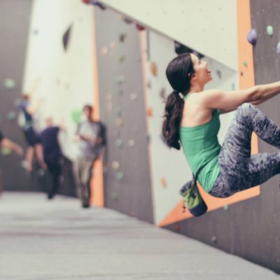 Woman in the foreground doing indoor bouldering