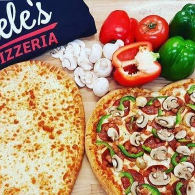 two heart shaped pizzas with a gisele's shirt and some veggies
