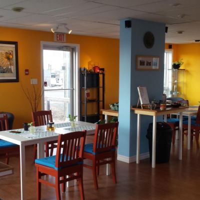 Inside of Lotus restaurant with yellow and blue walls with tables and chairs set up 
