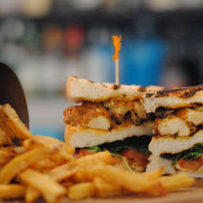 a toasted sandwich with fries and a silver fry cup