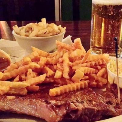 steak dinner with gravy, fries and other sides