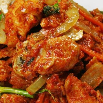 a tomato based curry dish with broccoli and onions