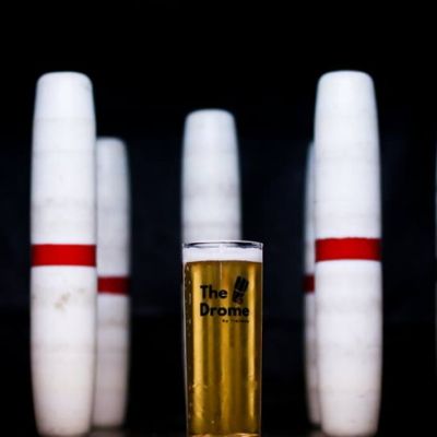 Bowling pins surrounding a pint of beer