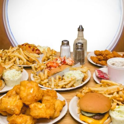 Table full of plates of food including burgers, fries, fish and chips