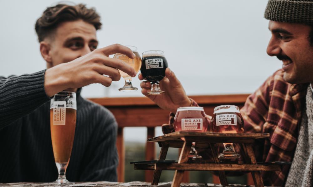 two men holding beers and toasting