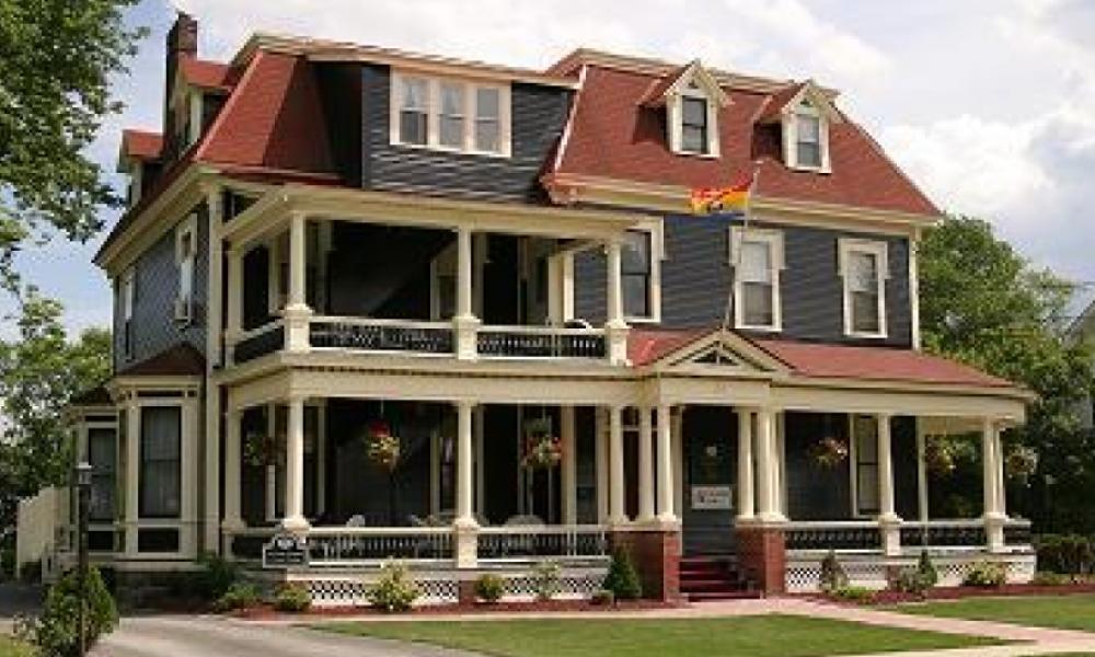 External shot of a three-story victorian-style house. 