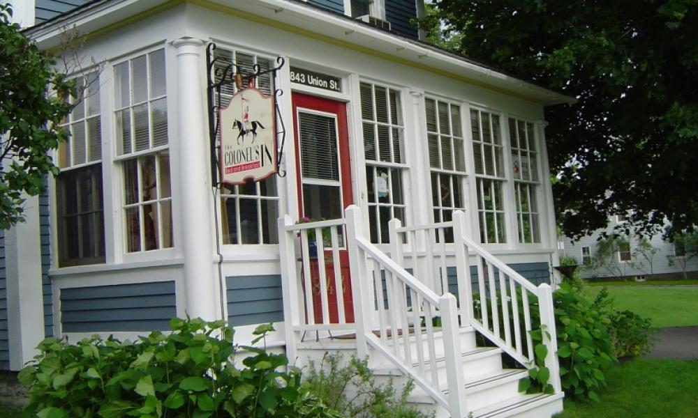 a white building with lots of windows and a red door