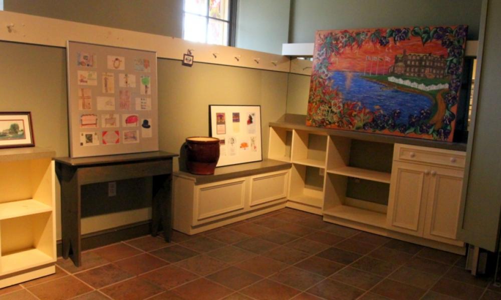 gallery display of art on top of cabinets and shelves