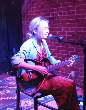 woman playing guitar and singing